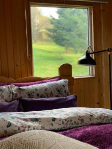 ein Schlafzimmer mit einem Fenster mit Kissen und einer Lampe in der Unterkunft Lavender Valley in Perekrestnoye