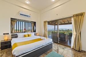 a bedroom with a large bed and a large window at SaffronStays Mango Lakeview Villa, Nashik in Nashik