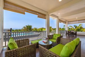 an outdoor patio with chairs and tables on a balcony at SaffronStays Mango Lakeview Villa, Nashik in Nashik