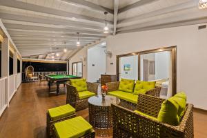 a living room with couches and a pool table at SaffronStays Mango Lakeview Villa, Nashik in Nashik