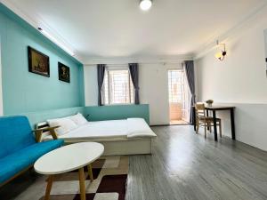 ein Wohnzimmer mit einem blauen Sofa und einem Tisch in der Unterkunft MINA HOUSE Airport Apartment in Ho-Chi-Minh-Stadt