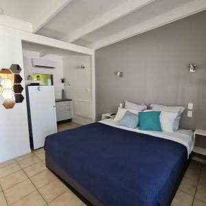 a bedroom with a large bed with blue sheets at Island Serenity on Magnetic Island in Nelly Bay