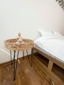 uma mesa de vime ao lado de uma cama num quarto em Buddha's apartment em Cluj-Napoca
