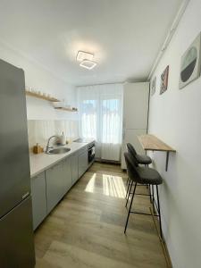 uma cozinha com armários brancos e uma mesa e cadeiras em Buddha's apartment em Cluj-Napoca