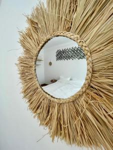 a round mirror with a rattan frame on a wall at Buddha's apartment in Cluj-Napoca
