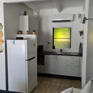 a kitchen with a white refrigerator and a window at Island Serenity on Magnetic Island in Nelly Bay