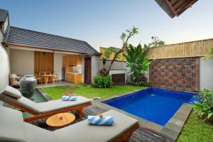 a backyard with a swimming pool and a house at Teratai Villa Canggu by Ini Vie Hospitality in Canggu