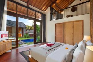 a bedroom with a large bed and a large window at Teratai Villa Canggu by Ini Vie Hospitality in Canggu