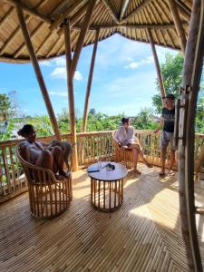 un gruppo di persone seduti su un ponte di Tropical Bali Bamboo Villa - 7 Minutes from Canggu a Dalung