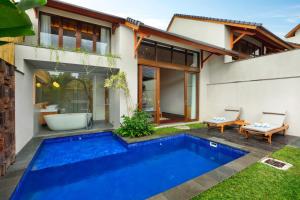 a swimming pool in front of a house at Teratai Villa Canggu by Ini Vie Hospitality in Canggu