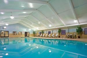 a pool in a hotel with chairs and tables at Holiday Inn South Plainfield-Piscataway by IHG in South Plainfield