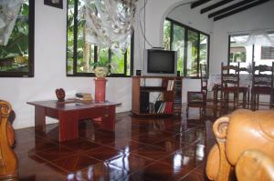 a living room with a table and a tv at Papaya Guesthouse in Mahe