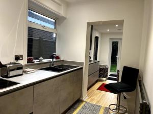 a kitchen with a counter and a chair in it at Warm and cosy city centre home near train station in Chichester