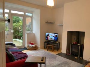 a living room with a couch and a tv at Warm and cosy city centre home near train station in Chichester