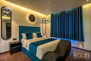 a bedroom with a large bed with blue curtains at Midas Hotel in Ho Chi Minh City