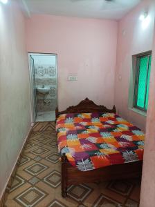 a bedroom with a bed and a bathroom with a sink at Gourinandan lodge in Puri