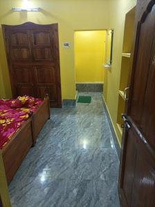 a bedroom with a bed and a yellow door at Gourinandan lodge in Puri