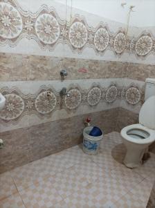 a bathroom with a toilet and a tiled floor at Gourinandan lodge in Puri
