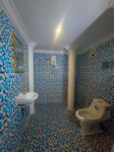 Baño de azulejos azules con aseo y lavamanos en Kep Villa Hill Guest House 1, en Kep