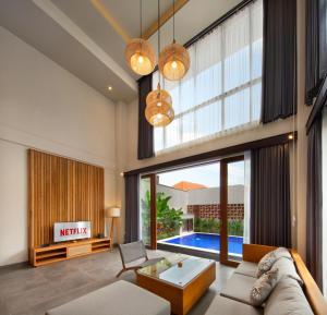 a living room with a couch and a table at Teratai Villa Canggu by Ini Vie Hospitality in Canggu