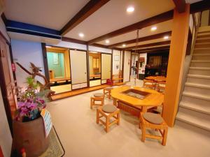sala de estar con mesa, sillas y escaleras en Hakuunsou en Takayama