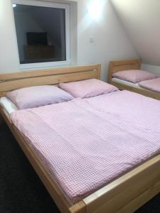 two twin beds in a room with a window at Apartmány u vleku - Podkrovní apartmán in Karlova Studánka