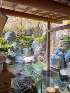 un bassin d'eau avec des rochers dans une cour dans l'établissement Hakuunsou, à Takayama