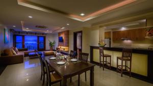 een keuken en een woonkamer met een tafel en stoelen bij Koh Samui Tower in Mae Nam