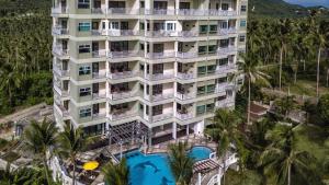 - une vue aérienne sur un hôtel doté d'une piscine et de palmiers dans l'établissement Koh Samui Tower, à Mae Nam Beach