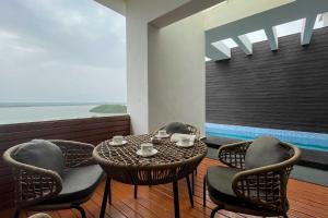 a table and chairs on a balcony with a view of the ocean at StayVista at Tarika's Seascapes with Pool & Home Theatre in Dabolim