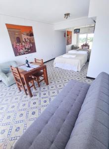 um quarto com duas camas, uma mesa e um sofá em "EL ESTUDIO" Alquiler Temporario de Departamentos em Mariano J. Haedo