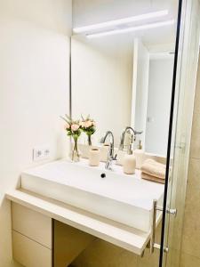 uma casa de banho com um lavatório branco e um espelho. em Hotel-Apartment with big terrace em Palma de Maiorca