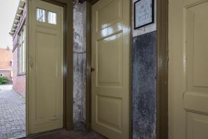 un pasillo vacío con dos puertas y una pared en d' âld skoalle - Sfeervol appartement in oude school., en Wijtgaard