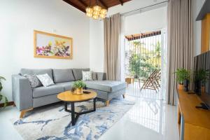uma sala de estar com um sofá e uma mesa em The Greens Luxury Boutique Villa em Karagampitiya