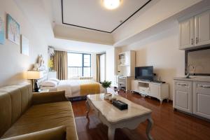 um quarto de hotel com uma cama, um sofá e uma televisão em Livetour Hotel Luogang Wanda Plaza Guangzhou em Guangzhou
