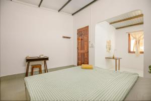 a bedroom with a bed with a yellow pillow on it at The Vibe House - Chillout Hostel in Phu Quoc