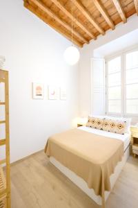 biała sypialnia z dużym łóżkiem i oknami w obiekcie Modern 3 bedroom, city center with patio & high ceilings by 10ToSea w Maladze