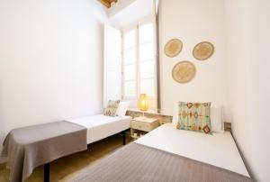 biały pokój z 2 łóżkami i oknem w obiekcie Modern 3 bedroom, city center with patio & high ceilings by 10ToSea w Maladze