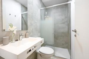 W łazience znajduje się toaleta, umywalka i prysznic. w obiekcie Modern 3 bedroom, city center with patio & high ceilings by 10ToSea w Maladze