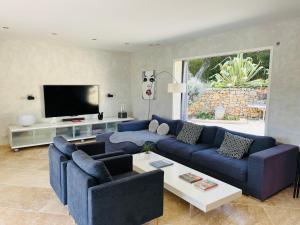 a living room with blue couches and a tv at Villa Casalive in Solliès-Pont