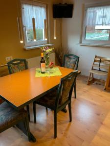 a dining room table with a bottle of wine on it at Jeanny´s Ferienwohnung in Thale