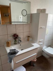 a bathroom with a sink and a toilet at Jeanny´s Ferienwohnung in Thale
