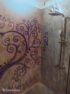 um chuveiro com um design na parede em Phong Nha Midtown hotel em Phong Nha