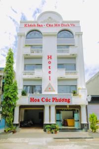 a large white building with a hko cafe pricing sign at Hoa Cúc Phương Hotel Dĩ An - Bình Dương in Dĩ An