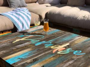 uma mesa de madeira com dois copos de vinho em Kaya La Provence na Cidade do Cabo