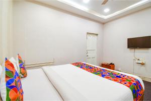 a bedroom with a bed and a flat screen tv at FabHotel Saltlake Regency in Kolkata
