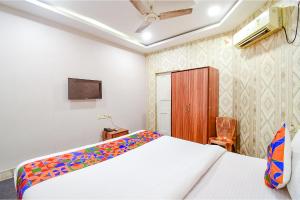 a hotel room with a bed and a tv at FabHotel Saltlake Regency in Kolkata