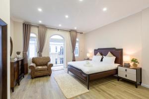 a bedroom with a bed and a chair and a window at L'amour Villa with Sauna at City Center in Da Nang