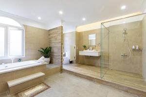 a bathroom with a shower and a tub and a sink at L'amour Villa with Sauna at City Center in Da Nang +46 photos