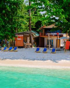 a group of chairs on a beach next to a house at Lipe Garden Beach Resort in Ko Lipe